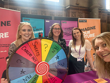Image of team at a stall with a colourful spinning wheel
