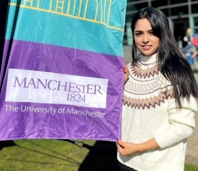 Bashirunnisa holding a UoM purple flag
