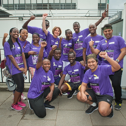 Group of people all wearing University of Manchester Purple tops for a race